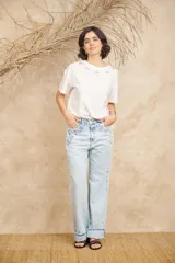 Pantalón de jean celeste de corte ancho con apliques bordados y desflecados.