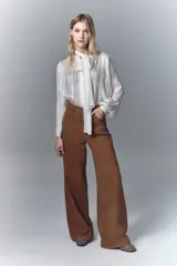 Pantalón jean de corte oxford tiro alto, confeccionado en denim rígido teñido en color habano. Con cierre y botón, y forrería estampada en los bolsillos.