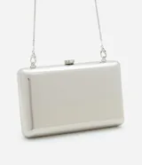 Cartera clutch plateada metalizada con cierre de broche y asa de cadena fina extraíble.