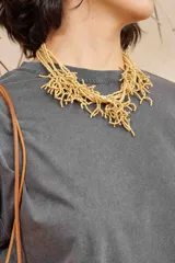 Collar corto con múltiples hilos de mostacillas color beige, con diseño que simula las ramas de un coral.