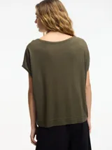 Remera negra con botones en la parte delantera y escote amplio, de mangas cortas. Confeccionada en viscosa y lino.