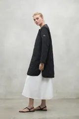 Campera acolchada color beige con patrón de rombos, cuello redondo y cierre con botones a presión.