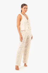 Chaleco de punto color crudo, con escote en V, abertura frontal y cierre con cordones.