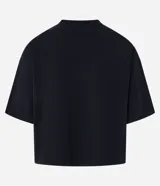 Remera negra de algodón con corte oversized, cuello redondo, mangas cortas y estampa tribal blanca en el pecho.