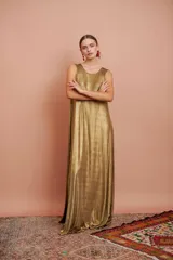 Vestido largo dorado sin mangas y de corte amplio.