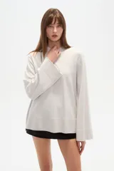 Sweater de viscosa color beige, con cuello polera, corte holgado y pespuntes decorativos en el frente.