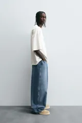 Pantalón de jean negro de corte amplio, estilo balloon fit, con cinco bolsillos y cierre frontal con botones.
