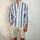 Camisa celeste y blanca a rayas verticales, de lino, con cuello mao y mangas largas con puños.