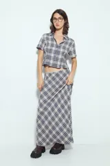 Falda larga de silueta fluida con estampado a cuadros en tonos marrones y beige. La prenda tiene una caída liviana y un calce cómodo.