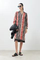 Vestido camisero midi con estampado abstracto en tonos beige, rojo y negro.