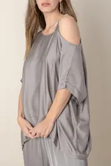 Blusa italiana gris de viscosa, lisa, con corte irregular y un hombro descubierto. De calce holgado.