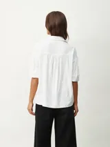 Camisa blanca de mangas cortas con textura.