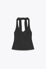 Top negro con cuello halter y escote en pico. Se ata con lazo en la espalda y tiene cierre lateral con cremallera oculta.