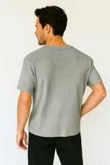Remera gris de algodón con cuello redondo y manga corta.