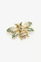 Pin metálico con forma de abeja en acabado dorado, decorado con incrustaciones de cristales tipo strass en colores verde, blanco y marrón.