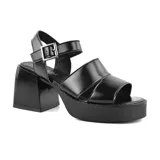 Sandalias de cuero color suela, con plataforma y taco cuadrado de madera. Tiras anchas cruzadas sobre el empeine y pulsera con hebilla metálica.