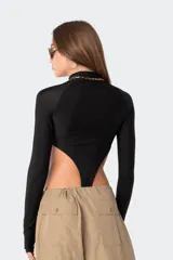 Body negro de lycra con cuello alto, mangas largas con orificio para el pulgar y aberturas en los laterales de la cadera.