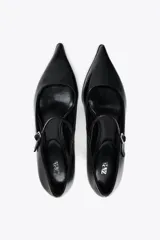 Zapato de cuero negro con tacón kitten, tira con hebilla ajustable y punta fina.