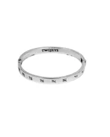 Pulsera rígida plateada con cierre de bisagra y grabados de líneas verticales.