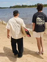 Camiseta color crema de algodón con cuello redondo y calce holgado. Estampa en la espalda con una palmera y texto en gris.