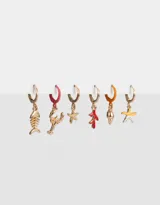 Set de seis aros dorados con forma de argolla, cada uno con un dije diferente con motivos marinos: esqueleto de pez, langosta, estrella de mar, coral, caracol y estrella de mar con detalles blancos.