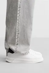 Zapatillas deportivas negras con detalle en blanco en la parte posterior y suela blanca con volumen de diseño irregular.