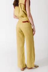 Pantalón de jean azul oscuro, de corte acampanado, con bolsillos delanteros con detalle de volados.