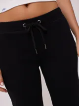 Pantalón deportivo tipo jogging color negro, confeccionado en 60% algodón y 40% poliéster, con cintura elástica ajustable con cordón, bolsillos laterales y puños ajustados con cierre en los tobillos.
