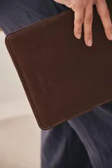 Funda porta iPad de cuero engrasado color marrón, con costuras a contratono y logo grabado.
