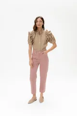 Camisa de lino color lila con volados en el cuello y en las mangas cortas abullonadas. Presenta un diseño de corte recto con cierre frontal de botones.