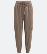 Pantalón jogger color marrón topo, de corte holgado, con cintura elástica ajustable con cordón, bolsillos laterales y bolsillos cargo con solapa en los laterales.