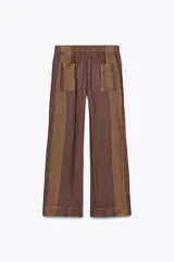 Pantalón de tiro medio confeccionado en hilatura de lino 100%. Cintura con elástico en espalda ajustable con cordones. Bolsillos laterales ocultos en costura y de plastrón en espalda.