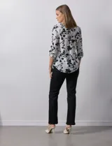 Blusa de gasa estampada con flores, marca Zac & Rachel. Tiene cuello a la base, escote en V y abertura con botones. Las mangas largas son de largo regulable.