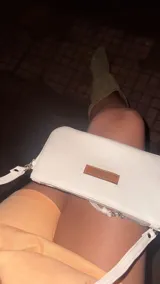 Cartera de mano tipo clutch, color marrón, confeccionada en cuero.