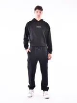 Pantalón de jogging negro con bolsillos laterales tipo cargo, cintura elastizada con cordón ajustable y puños ajustados.
