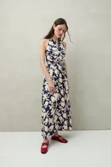 Vestido largo de algodón liviano con estampado floral en tonos azul y blanco, escote halter y lazo que se anuda al cuello.