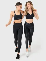 Calza deportiva negra con tela brillante, tiro alto y cintura en forma de "V" con silicona interior.