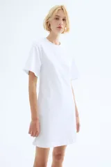 Vestido corto en punto de algodón suave con cuello redondo ribeteado acanalado, hombros caídos y mangas al codo. Pinzas moldeadoras en la parte posterior de la cintura para estilizar la figura.