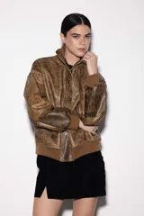 Chaqueta bomber de cuero color marrón con efecto vintage, cuello alto, cierre frontal con cremallera y bolsillos laterales. Puños y cintura de punto acanalado color marrón. Talle único.