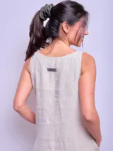 Vestido largo sin mangas color beige con ruedo verde, de corte amplio y estilo casual.