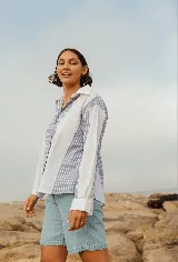 Camisa oversize de lino a rayas verticales azules y blancas, con cuello clásico y mangas largas.