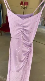 Vestido midi lila con estampado de lunares, escote corazón, breteles finos y falda con frunces laterales.