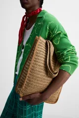 Bolso tipo shopper color marrón claro, con acabado trenzado. Tiene un compartimento principal con cierre de imán y un bolsillo plano interior. Cuenta con dos asas de mano.
