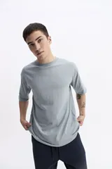 Remera lisa color beige de corte oversize, con escote redondo y mangas cortas.