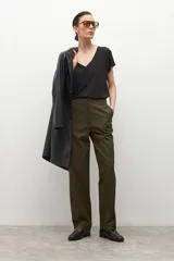 Pantalón de corte recto y tiro medio en color verde oliva, con cierre frontal de cremallera y botón, y bolsillos laterales.