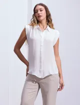Blusa negra de gasa marca Tahari, con cuello a la base con solapa, abertura central con botones ocultos y detalle plisado en hombros.