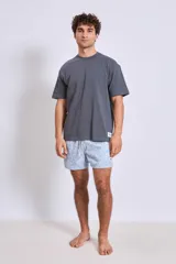 Bañador de hombre corto, color celeste claro con estampado floral en tonos rosados y beige. Posee cordón ajustable en la cintura.