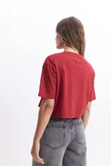 Remera corta color verde lima con estampado frontal de un corazón y la frase "love is a verb".