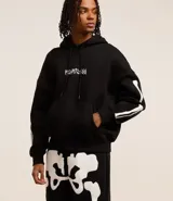Buzo negro de fleece con felpa, corte boxy, capucha con cordón ajustable, manga larga, estampa lettering frontal, bolsillo canguro, patch de esqueleto en la manga y puños ajustados.