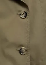 Chaqueta corta color verde oliva con cuello de pico con solapa, cierre cruzado con doble botonadura, solapas con muesca, dos bolsillos laterales y manga larga.